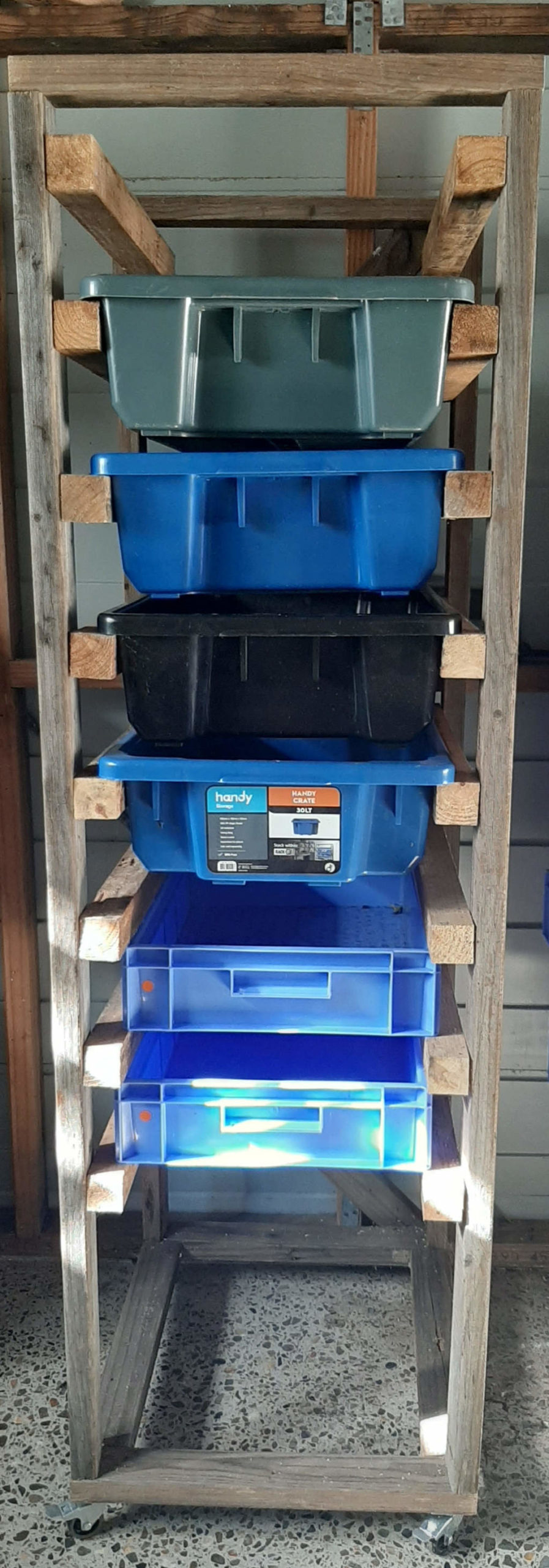 Photo of a wood mealworm rack with 5 trays. The mealworm rack has wood sliders which support the trays.